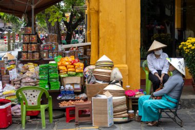 Hoi An, Vietnam-1 Mar 2024: Vietnamlı sokak satıcısı Hoi An, Vietnam 'da sokakta yerel yiyecek satıyor. Vietnam seyahatinde Vietnam sokak yemeklerini kaçırmamalısın.