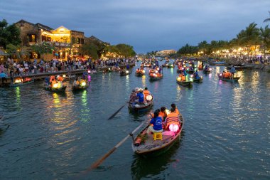 Hoi An, Vietnam-1 Mar 2024: Turistler Hoi An, Vietnam 'daki Bon Nehri' nde tekne turunun tadını çıkarıyorlar. Hoi Bir fener tekne gezisi aktiviteleri çoğunlukla eski kasaba bölgesinde gerçekleşir