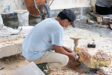 Danang, Vietnam-27 Şubat, 2024: İşçi el Danang, Vietnam 'da mermer bir taş oyuyor. Non Nuoc taş oyma köyü geleneksel bir zanaat köyü olarak kabul edilir.