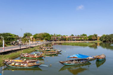 Hoi An, Vietnam- 29 Şubat 2024: Hoi An, Vietnam 'da antik mimarinin önündeki geleneksel tekneler. Hoi An, karışık kültürler ve mimari ile ünlü Dünya Kültür Mirası sitesidir..