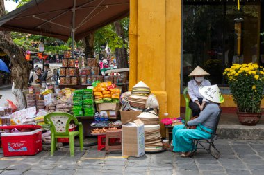 Hoi An, Vietnam-1 Mar 2024: Vietnamlı sokak satıcısı Hoi An, Vietnam 'da sokakta yerel yiyecek satıyor. Vietnam seyahatinde Vietnam sokak yemeklerini kaçırmamalısın.