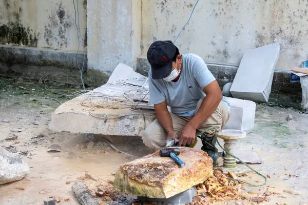 Danang, Vietnam-27 Şubat, 2024: İşçi el Danang, Vietnam 'da mermer bir taş oyuyor. Non Nuoc taş oyma köyü geleneksel bir zanaat köyü olarak kabul edilir.