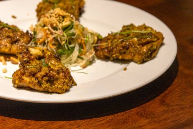 Vietnam usulü ızgara tavuk ve beyaz tabakta limon otu.