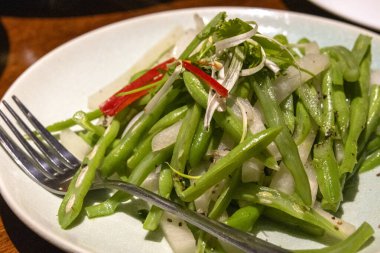 Kızarmış fasulyeyi beyaz tabakta karıştır.