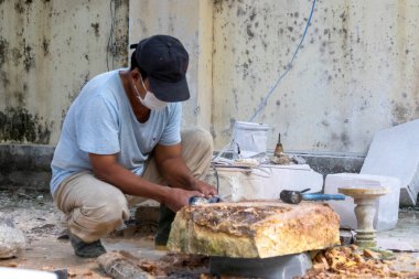 Danang, Vietnam-27 Şubat, 2024: İşçi el Danang, Vietnam 'da mermer bir taş oyuyor. Non Nuoc taş oyma köyü geleneksel bir zanaat köyü olarak kabul edilir.