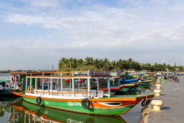 Hoi An, Vietnam- 1 Mar, 2024: Hoi An, Vietnam 'daki nehir boyunca turist parkı boyunca tekneler kullanılırdı. Hoi An, karma kültür ve mimarisi ile ünlü Dünya Kültür Mirası sitesidir..