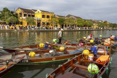 Hoi An, Vietnam-1 Mar 2024: Kayıkçılar Hoi An, Vietnam 'da turistleri bekliyorlar. Hoi Bir fener tekne gezisi aktiviteleri çoğunlukla eski kasaba bölgesinde gerçekleşir