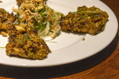 Vietnam usulü ızgara tavuk ve beyaz tabakta limon otu.