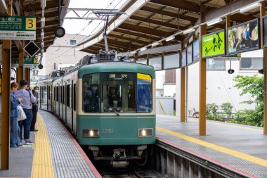 Kamakura, Japonya - 14 Mayıs 2024: Enoshima Electric Railway treni Japonya 'daki istasyona yaklaşıyor. Enoden, Japonya 'daki en eski altıncı demiryoludur.