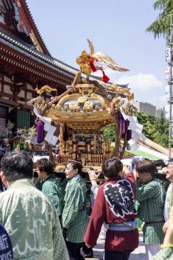Tokyo, Japonya - 18 Mayıs 2024: Asakusa 'daki Sanja Festivali' nde taşınabilir bir türbe (mikoshi) taşıyan insanlar. Tokyo 'nun en popüler festivallerinden biridir..