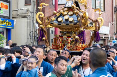 Tokyo, Japonya - 18 Mayıs 2024: Asakusa 'daki Sanja Festivali' nde taşınabilir bir türbe (mikoshi) taşıyan insanlar. Tokyo 'nun en popüler festivallerinden biridir..