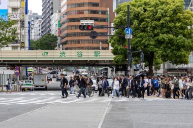 Tokyo, Japonya - 12 Mayıs 2024: İnsanlar Shibuya, Tokyo 'da işlek kavşağı geçiyor. Burası dünyanın en işlek kavşaklarından biri..