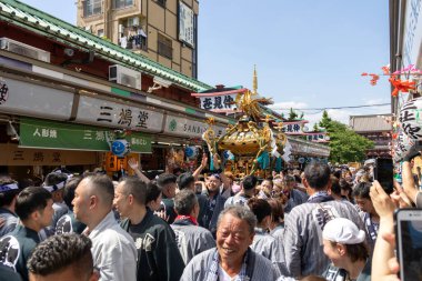 Tokyo, Japonya - 18 Mayıs 2024: Asakusa 'daki Sanja Festivali' nde taşınabilir bir türbe (mikoshi) taşıyan insanlar. Tokyo 'nun en popüler festivallerinden biridir..