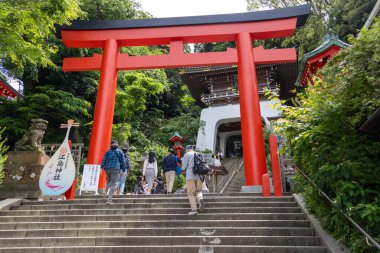 Enoshima, Japonya - 14 Mayıs 2024: Enoshima Tapınağı 'nın girişindeki kırmızı torri kapısı. Enoshima Tapınağı balıkçılık ve deniz taşımacılığının sıradan tanrılarına ibadet etmek için inşa edildi.