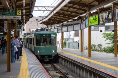 Kamakura, Japonya - 14 Mayıs 2024: Enoshima Electric Railway treni Japonya 'daki istasyona yaklaşıyor. Enoden, Japonya 'daki en eski altıncı demiryoludur.