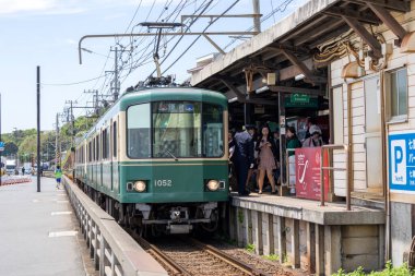 Kamakura, Japonya - 14 Mayıs 2024: Enoshima Electric Railway treni Japonya 'daki istasyona yaklaşıyor. Enoden, Japonya 'daki en eski altıncı demiryoludur.