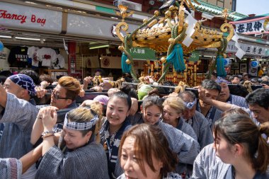 Tokyo, Japonya - 18 Mayıs 2024: Asakusa 'daki Sanja Festivali' nde taşınabilir bir türbe (mikoshi) taşıyan insanlar. Tokyo 'nun en popüler festivallerinden biridir..