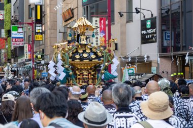 Tokyo, Japonya - 18 Mayıs 2024: Asakusa 'daki Sanja Festivali' nde taşınabilir bir türbe (mikoshi) taşıyan insanlar. Tokyo 'nun en popüler festivallerinden biridir..