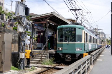 Kamakura, Japonya - 14 Mayıs 2024: Enoshima Electric Railway treni Japonya 'daki istasyona yaklaşıyor. Enoden, Japonya 'daki en eski altıncı demiryoludur.