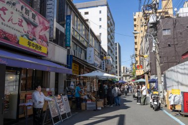 Tokyo, Japonya - 11 Mayıs 2024: İnsanlar Tokyo 'daki Tsukiji Dış Pazarı' nı ziyaret ediyor. Tsukiji Dış Pazarı bir gurme harikalar diyarı, özellikle de deniz ürünleri severler için.