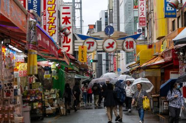 Tokyo, Japonya - 13 Mayıs 2024: Tokyo, Japonya 'daki Ameyoko market mahallesi. Ameyoko Alışveriş Sokağı yükseltilmiş demiryolu hattının altında bir mağaza koleksiyonudur..