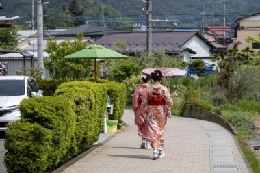 Shimoyoshida, Japonya - 15 Mayıs 2024: Geleneksel Japon kıyafetleri giyen turistler Shimoyoshida İstasyonu, Jpaan 'a doğru yürüyor.