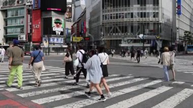 Tokyo, Japonya - 12 Mayıs 2024: İnsanlar Shibuya, Tokyo 'da işlek kavşağı geçiyor. Burası dünyanın en işlek kavşaklarından biri..