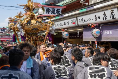 Tokyo, Japonya - 18 Mayıs 2024: Asakusa 'daki Sanja Festivali' nde taşınabilir bir türbe (mikoshi) taşıyan insanlar. Tokyo 'nun en popüler festivallerinden biridir..