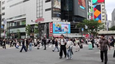 Tokyo, Japonya - 12 Mayıs 2024: İnsanlar Shibuya, Tokyo 'da işlek kavşağı geçiyor. Burası dünyanın en işlek kavşaklarından biri..