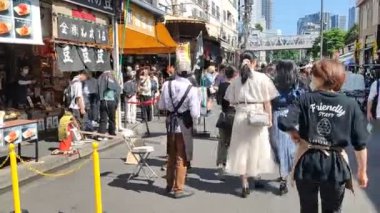 Tokyo, Japonya - 11 Mayıs 2024: İnsanlar Tokyo 'daki Tsukiji Dış Pazarı' nı ziyaret ediyor. Tsukiji Dış Pazarı bir gurme harikalar diyarı, özellikle de deniz ürünleri severler için.