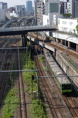 Tokyo, Japonya - 15 Mayıs 2024: Tokyo, Japonya 'daki Shinjuku tren istasyonuna yaklaşan trenler. Shinjuku Japonya 'daki en büyük tren istasyonlarından biridir..