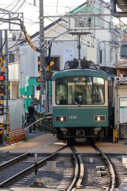 Kamakura, Japonya - 14 Mayıs 2024: Kamakura, Japonya 'daki Enoshima Dentetsu tren hattı. Eski cazibesini deniz kenti Kamakura 'da sergiliyor.