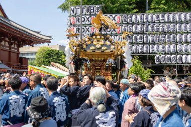 Tokyo, Japonya - 18 Mayıs 2024: Asakusa 'daki Sanja Festivali' nde taşınabilir bir türbe (mikoshi) taşıyan insanlar. Tokyo 'nun en popüler festivallerinden biridir..