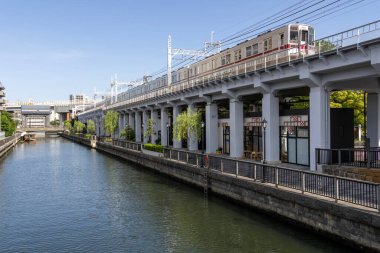 Tokyo, Japonya- 11 Mayıs 2024: Tokyo 'daki Kita Jyukken-gawa' dan yerel bir tren geçiyor. 