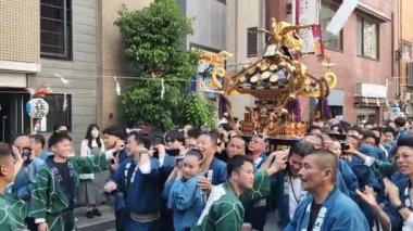 Tokyo, Japonya - 18 Mayıs 2024: Asakusa 'daki Sanja Festivali' nde taşınabilir bir türbe (mikoshi) taşıyan insanlar. Tokyo 'nun en popüler festivallerinden biridir..