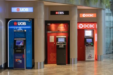 Singapur - 7 Mayıs 2024: Changi Havaalanı Terminali 2 'deki ATM' ler (otomatik veznedarlar). ATM, banka hesap sahibinin parasını yönetmeyi kolaylaştıran özel bir bilgisayardır..