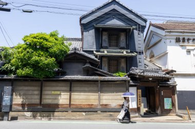 Kawagoe, Japonya - 17 Mayıs 2024: Kawagoe, Japonya 'da bir yol boyunca Edo dönemindeki ev ve binalar. Kawagoe, Edo döneminden kalma geleneksel ve zengin tarihi mirasın bir karışımını sunuyor..