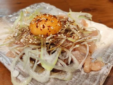 Yukhoe usulü çiğ yumurta ve soğanlı tavuk, Kore usulü doğranmış çiğ ettir.