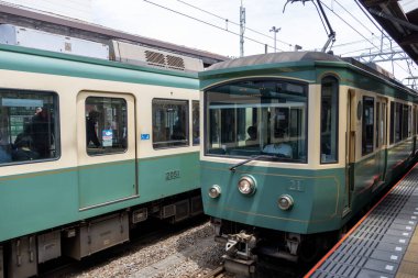 Kamakura, Japonya - 14 Mayıs 2024: Enoshima Electric Railway treni Japonya 'daki istasyona yaklaşıyor. Enoden, Japonya 'daki en eski altıncı demiryoludur.