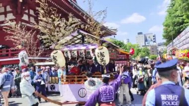 Tokyo, Japonya - 18 Mayıs 2024: Asakusa 'daki Sanja Festivali' nde taşınabilir bir türbe (mikoshi) taşıyan insanlar. Tokyo 'nun en popüler festivallerinden biridir..