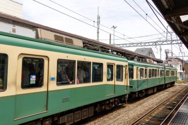 Kamakura, Japonya - 14 Mayıs 2024: Enoshima Electric Railway treni Japonya 'daki istasyona yaklaşıyor. Enoden, Japonya 'daki en eski altıncı demiryoludur.