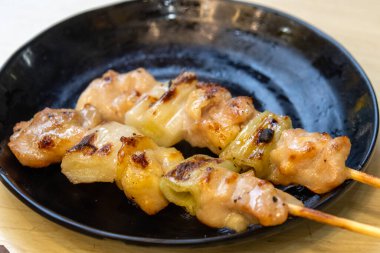 Japon yemeği yakitori, tavuk ve sığır eti, masada servis ediliyor.