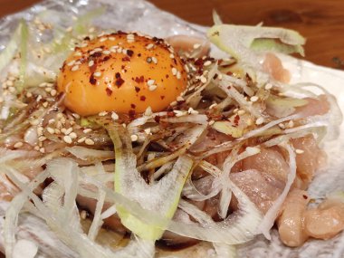 Yukhoe usulü çiğ yumurta ve soğanlı tavuk, Kore usulü doğranmış çiğ ettir.