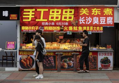 Guangzhou, Çin-7 Haziran 2014: Çin 'in Guangzhou kentindeki Shang Xia Jiu yürüyüş sokağında sokak yemekleri satıcısı
