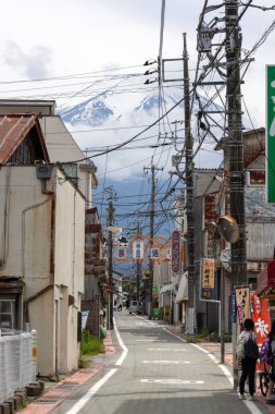 Shimoyoshida, Japonya - 15 Mayıs 2024: Shimoyoshida, Japonya 'daki Nishi Ura Doori Caddesi' nden Fuji Dağı 'na doğru bakın. Şehir ve Mt. Dağın çarpıcı derecede fotojenik bir manzarası var. Fuji