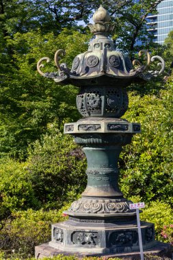 Tokyo, Japonya - 11 Mayıs 2024: Tokyo 'daki Zojo-ji Tapınağı bahçesinde geleneksel bronz fener (toro). Fenerler Buda 'ya adak olarak kabul edilir.
