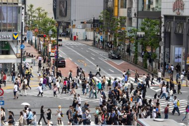 Tokyo, Japonya - 12 Mayıs 2024: İnsanlar Shibuya, Tokyo 'da işlek kavşağı geçiyor. Burası dünyanın en işlek kavşaklarından biri..