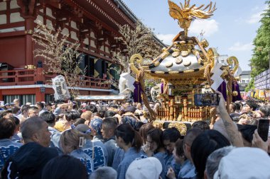 Tokyo, Japonya - 18 Mayıs 2024: Asakusa 'daki Sanja Festivali' nde taşınabilir bir türbe (mikoshi) taşıyan insanlar. Tokyo 'nun en popüler festivallerinden biridir..