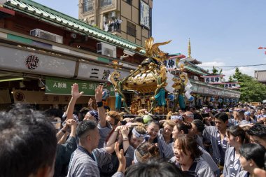 Tokyo, Japonya - 18 Mayıs 2024: Asakusa 'daki Sanja Festivali' nde taşınabilir bir türbe (mikoshi) taşıyan insanlar. Tokyo 'nun en popüler festivallerinden biridir..