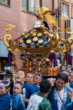 Tokyo, Japonya - 18 Mayıs 2024: Asakusa 'daki Sanja Festivali' nde taşınabilir bir türbe (mikoshi) taşıyan insanlar. Tokyo 'nun en popüler festivallerinden biridir..